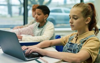 Children on laptops in classroom