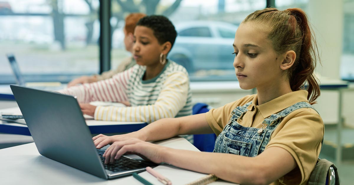 Children on laptops in classroom
